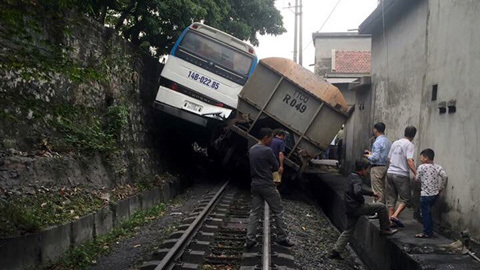 Ô tô 45 chỗ bị tàu chở than nhấc bổng, mắc kẹt giữa kè đá