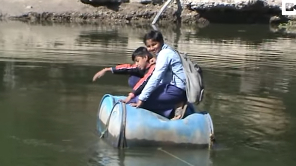 Mạo hiểm vượt sông đi học trên thùng nhựa