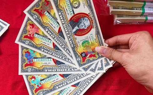 Chi tiền triệu mua 2 USD hình chó mạ vàng biếu Tết