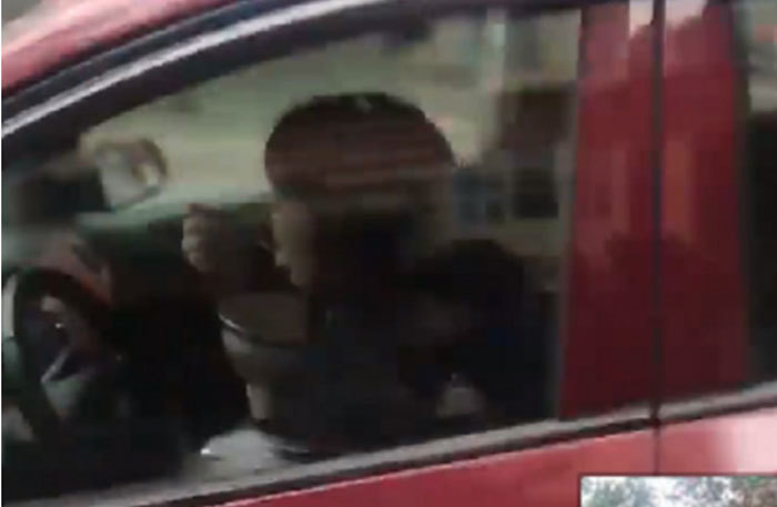 Nữ tài xế vừa cầm bát ăn vừa lái ô tô trên phố Hà Nội