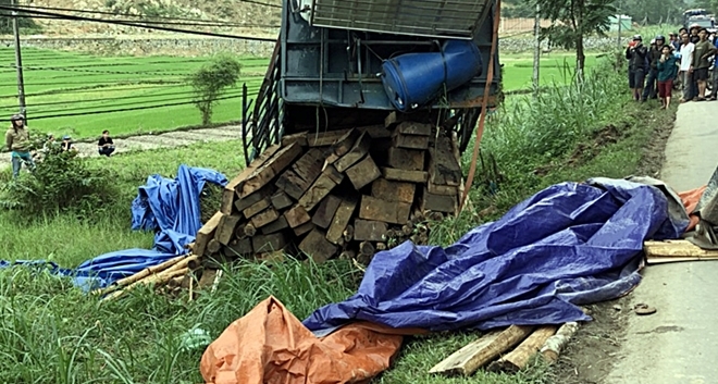 Xe tải chở keo bị lật, lộ hàng chục phách gỗ lậu